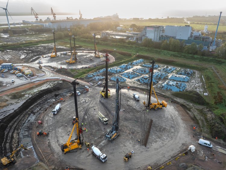 The picture shows the construction site from above. You can see 4 frames. In the background you can see wind turbines.