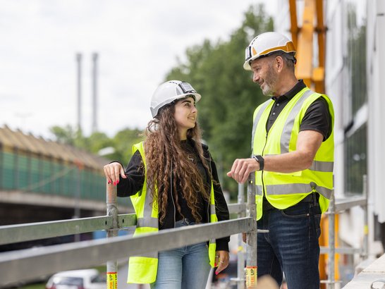 Bild zeigt zwei Bauarbeiter auf der Baustelle. 