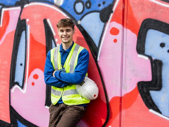 Stock image. Construction workers in front of graffiti.