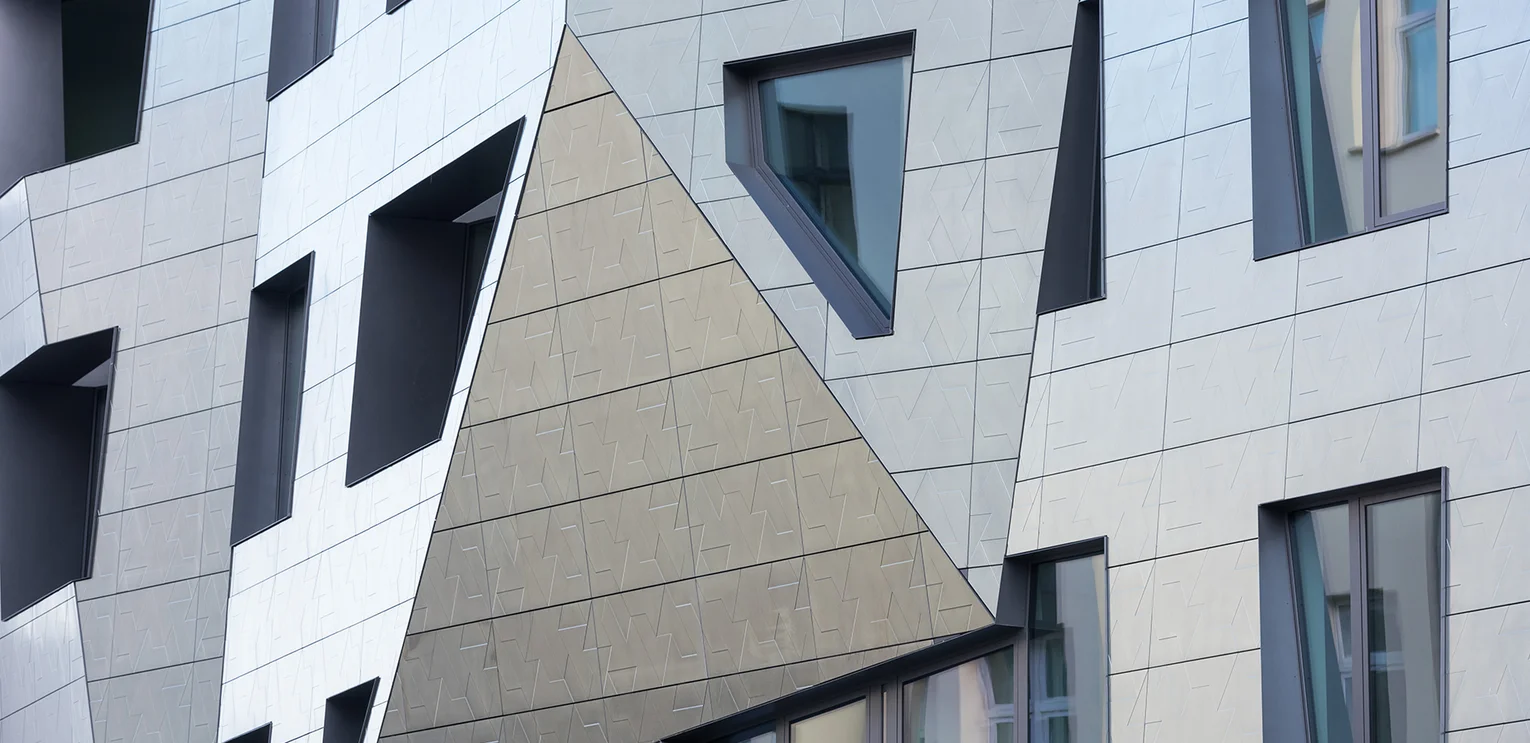 SAPPHIRE by Daniel Libeskind Photo: Sapphire by Daniel Libeskind in Berlin: Detailed view of the silver shimmer of the façade. The façade was coated with an extra manufactured metal powder. This makes the building appear different colours, depending on where the light falls.