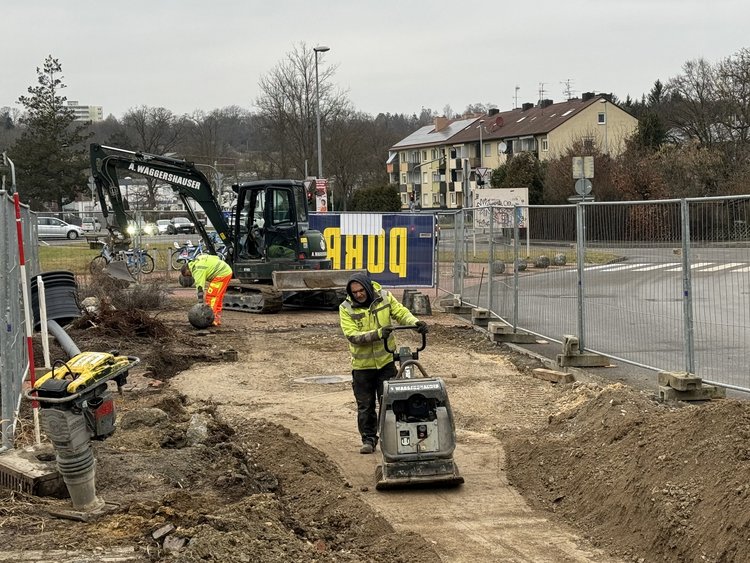 The picture shows a construction worker working on levelling the ground.