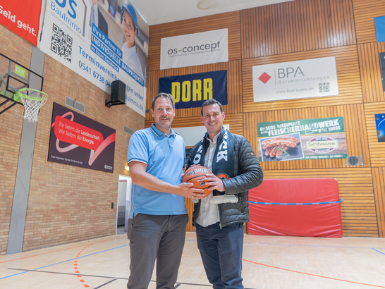 Zwei Männer halten einen Basketball in einer Basketballhalle der GiroLive Panthers