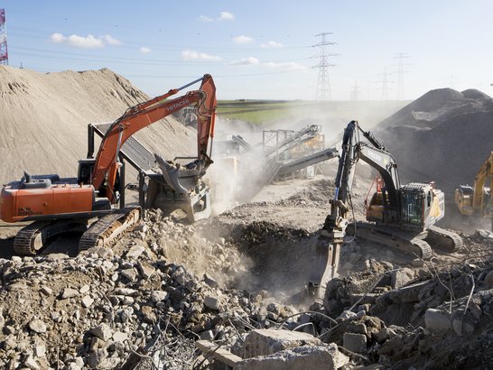 The image shows the recycling plant with three excavators.