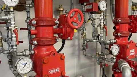 Bild ist das Imagebild für den Leistungsbereich Facility Service. Man sieht rote Rohre an der Wand