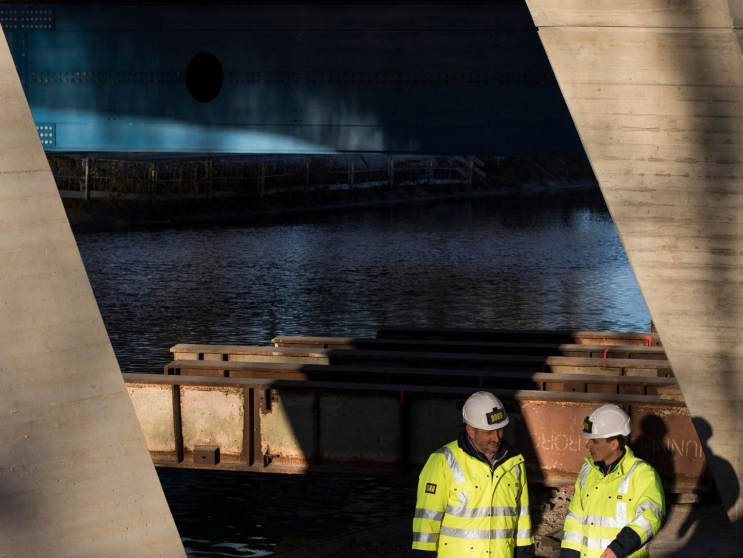 Imagebild, zwei Bauarbeiter unter einer Brücke 