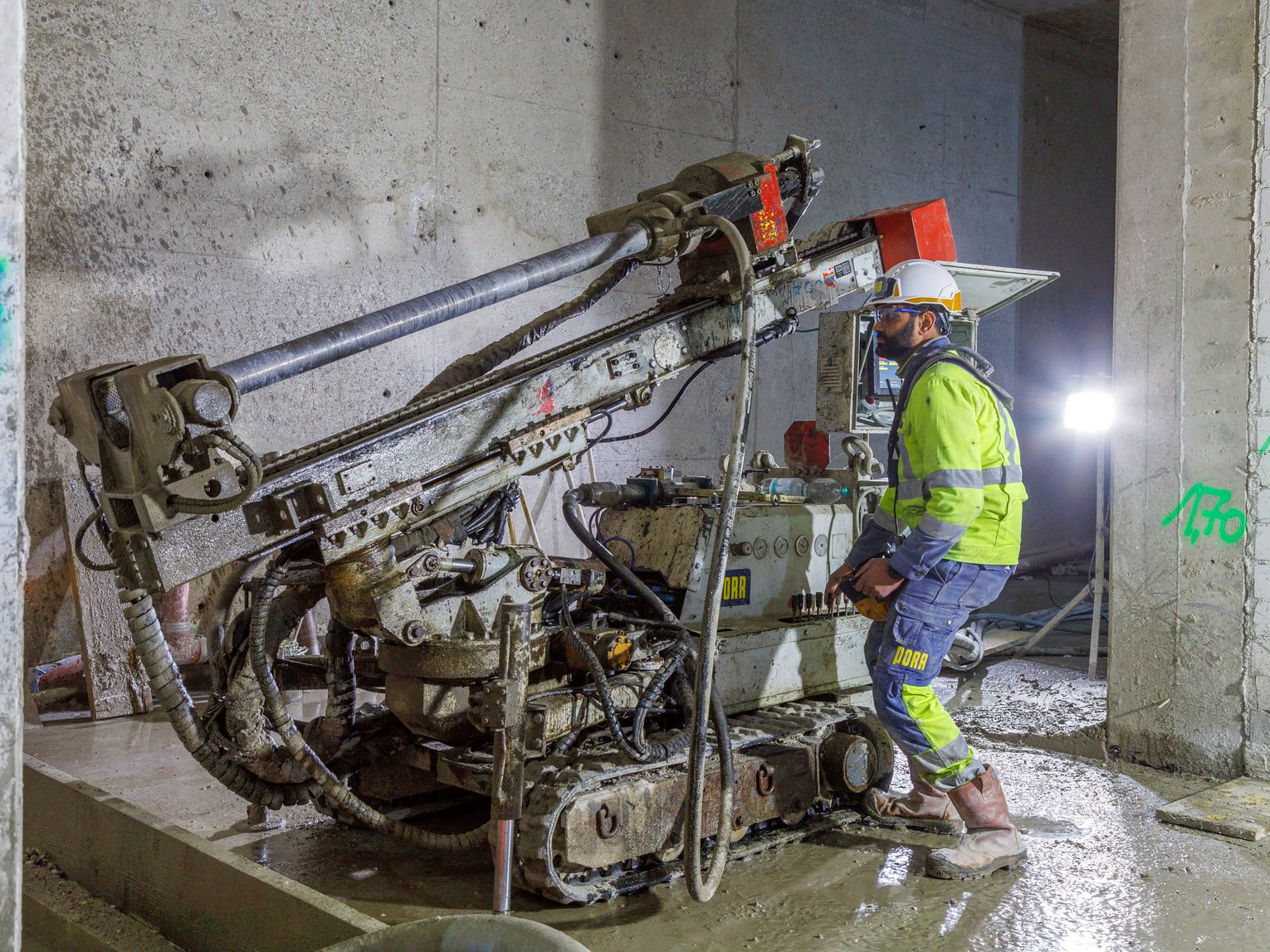 Drilling work as part of specialist civil engineering at the Neue Pinakothek in Munich: a member of staff operates an anchor drilling rig to install underground anchors within the construction site area.