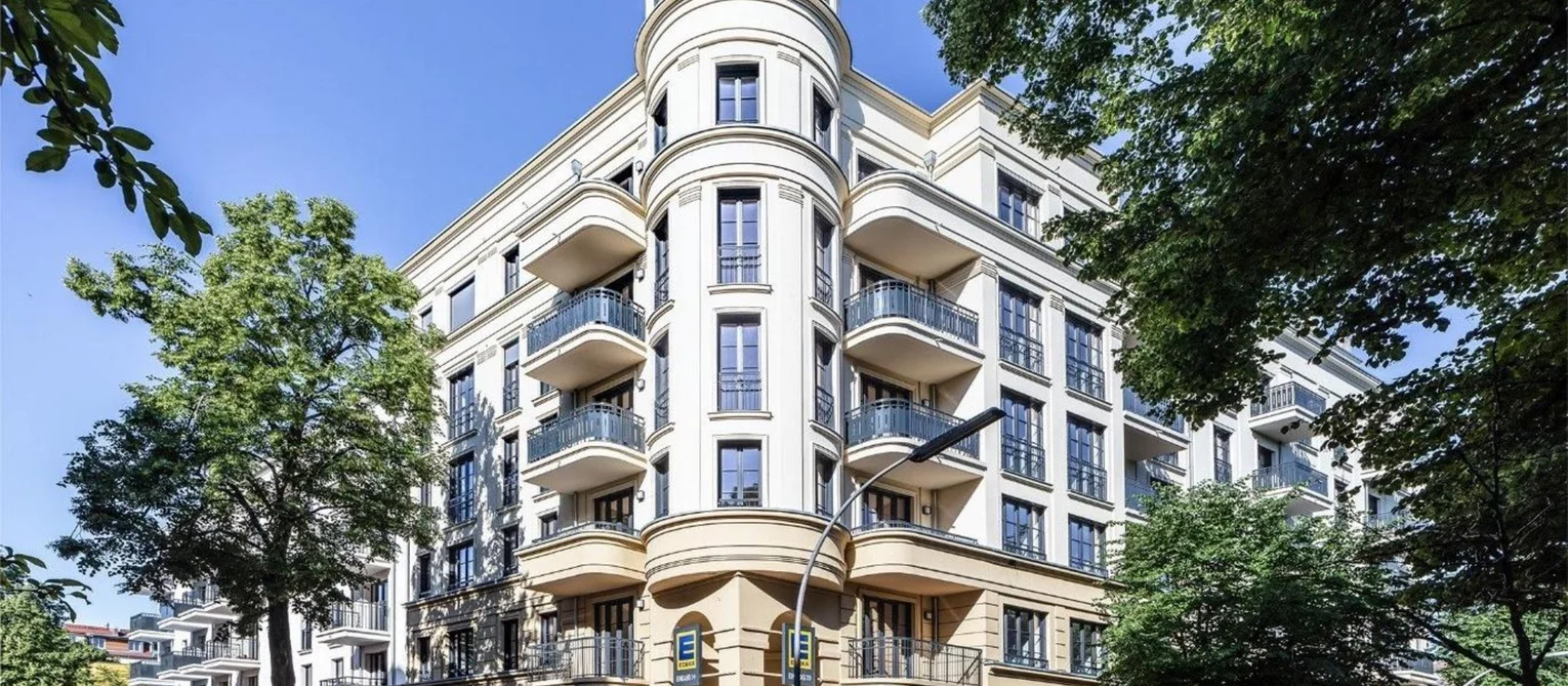A new twist on traditional nineteenth-century architecture Exterior view of the corner tower. The tower is the highest point of the building complex and has seven storeys. The buildings on either side of the tower have first six and then five storeys. The facade is the colour of sandstone. The French windows and balconies form a single unit.