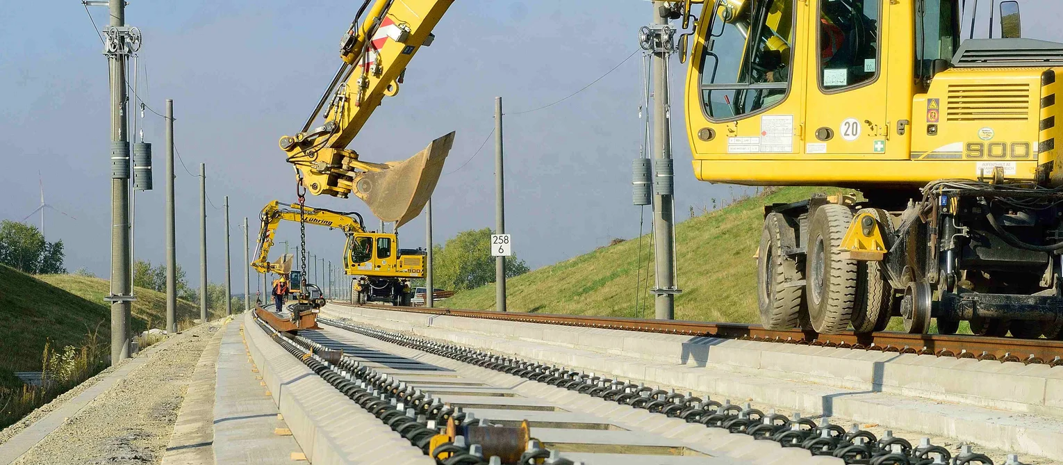 Photo: High-speed railway line Erfurt–Leipzig/Halle: two yellow excavators work on a slab track section.