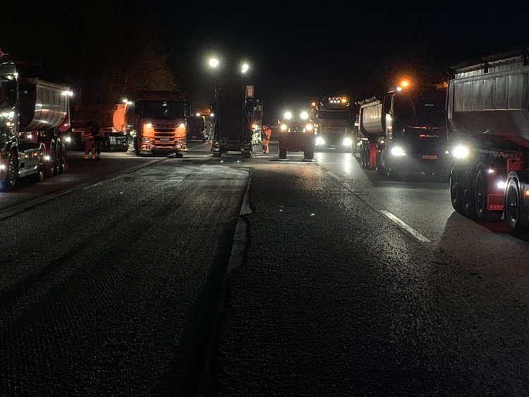 The picture shows the work in the dark. You can only see the headlights of the construction equipment.