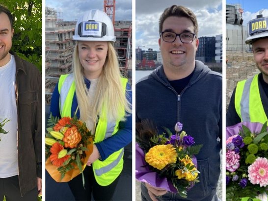 4 Personen mit Blumenstrauß in der Hand und Baukleidung an. 