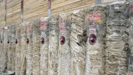 Bild einer Bohrpfahlwand; Zusätzlich wurde diese mit Verpressankern gesichert