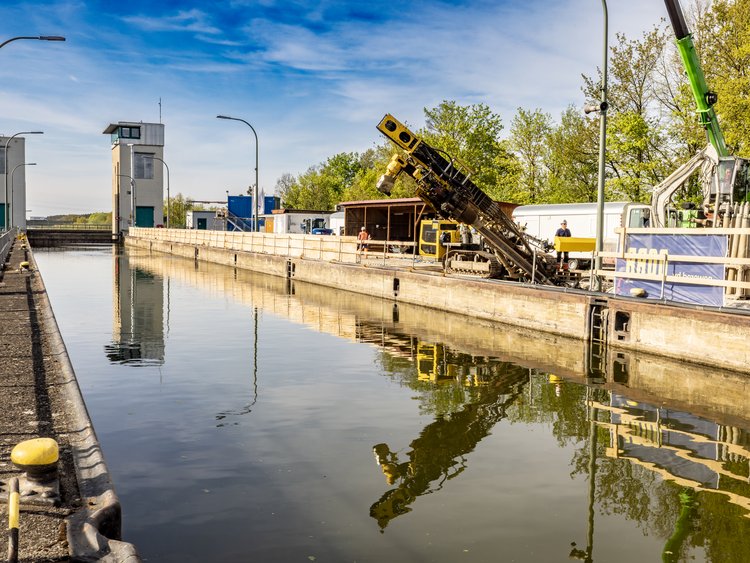 Picture shows the Strullendorf lock at the lock basin. A piece of specialised civil engineering equipment stands at the edge
