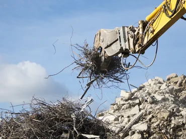 Bild zeigt einen greifer, der Müll trennt. Es ist ein Bild aus dem Leistungsbereich Umwelttechnik und zeigt Abfallmanagement