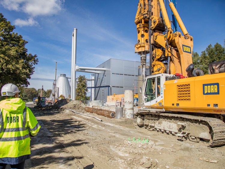 The picture shows a PORR construction worker standing next to a drilling rig.