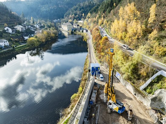 The image shows a river. At the bottom right, you can see a pile driver used in specialised civil engineering.