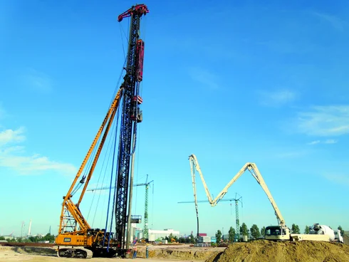 Bild zeigt das Betonieren eines Simplexpfahls mit mobiler Betonpumpe; Eine Ramme steht rechts im Bild