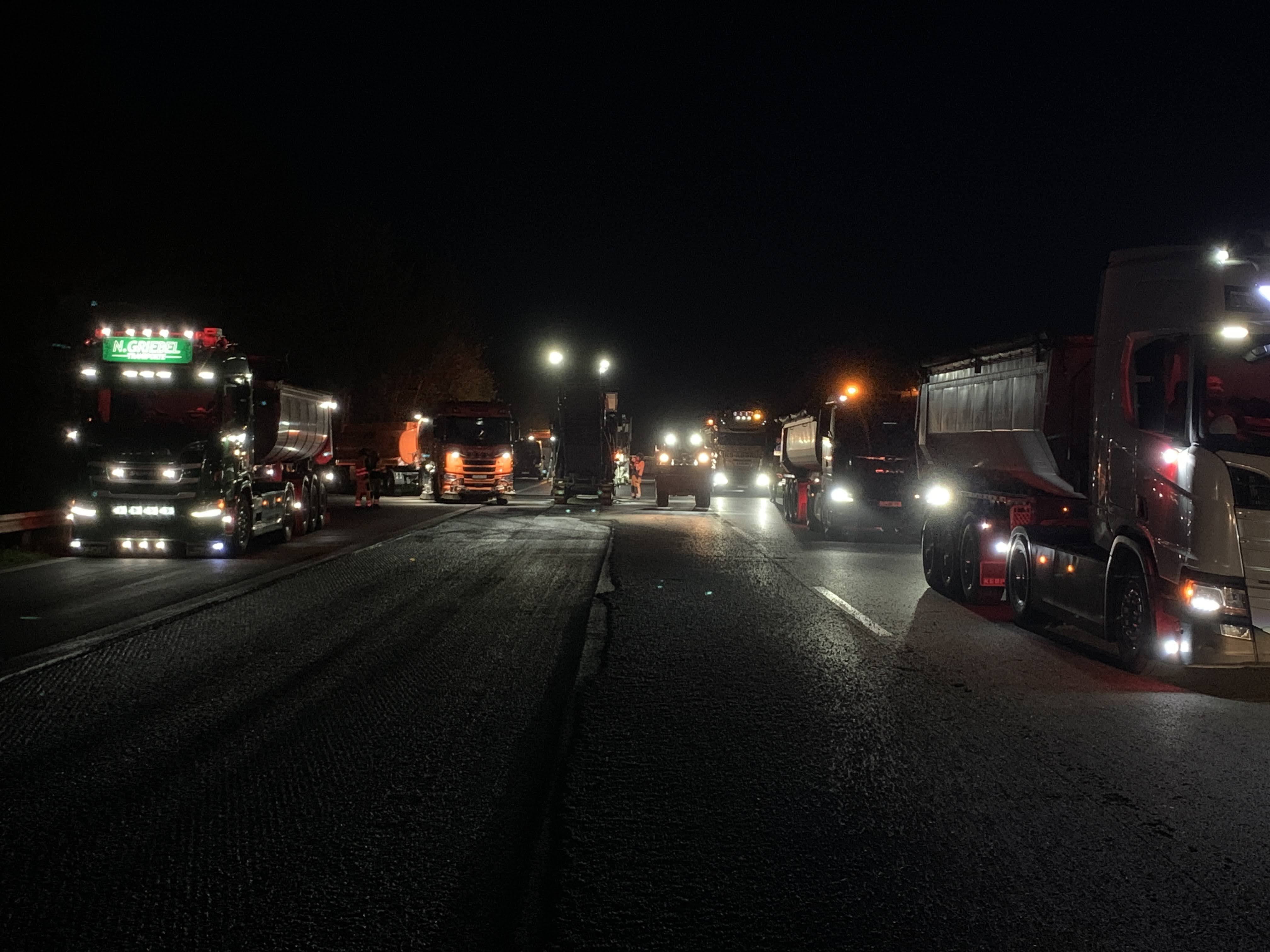 The picture shows the work in the dark. You can only see the headlights of the construction equipment.